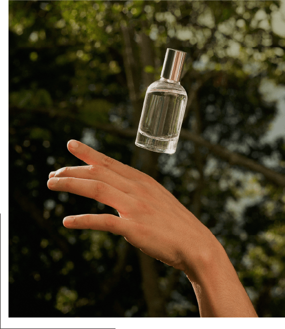 a glass bottle floats magically above a hand